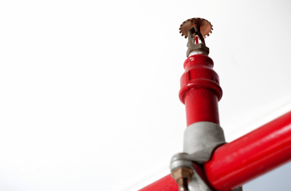 Close-up of a red fire sprinkler head on a pipe