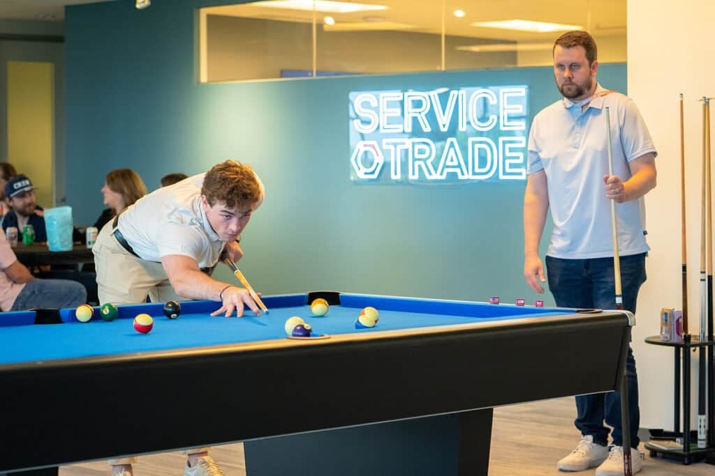 Two servicetrade crew members playing pool during st days 2026